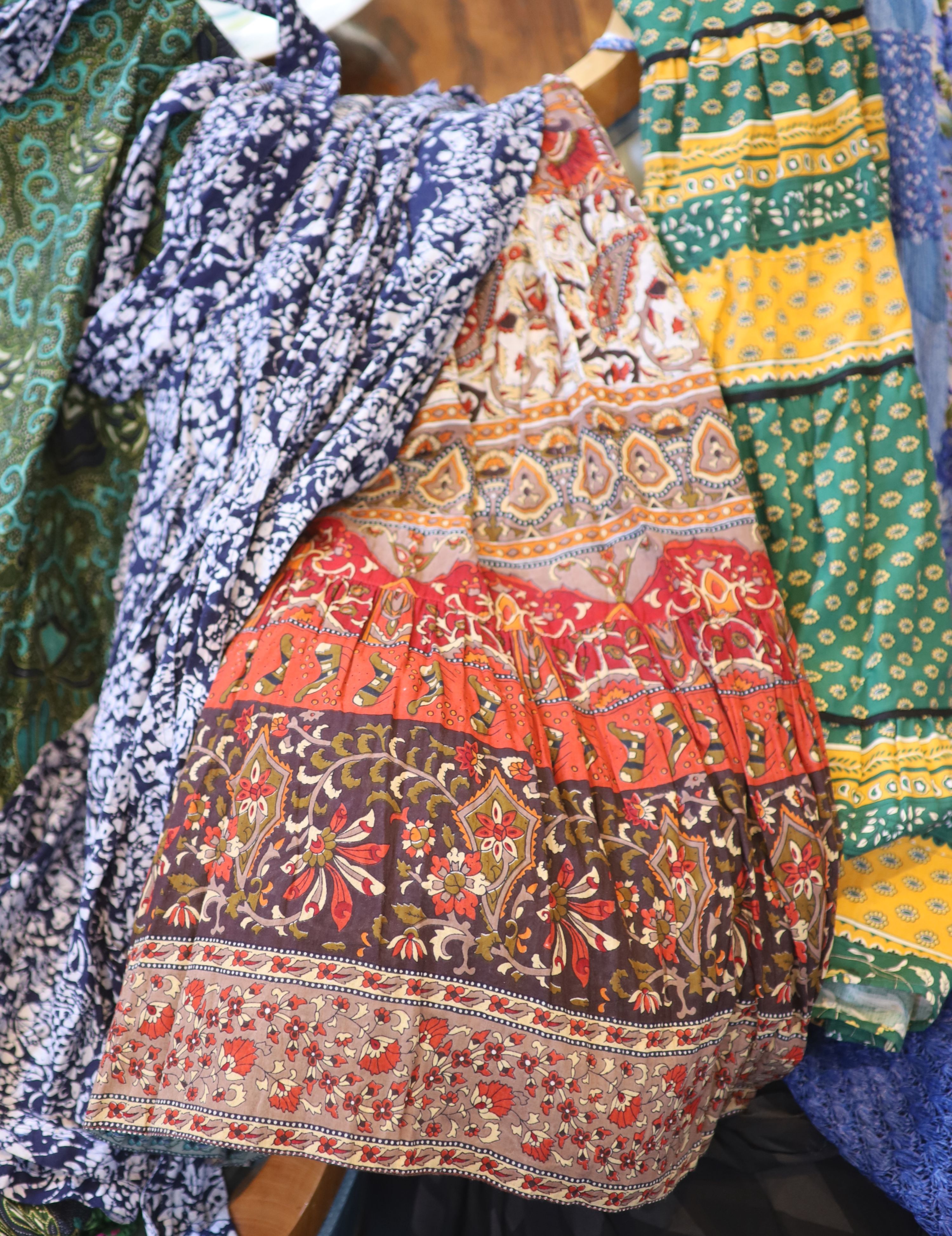 A large collection of fabric skirts including a raffier skirt in blue